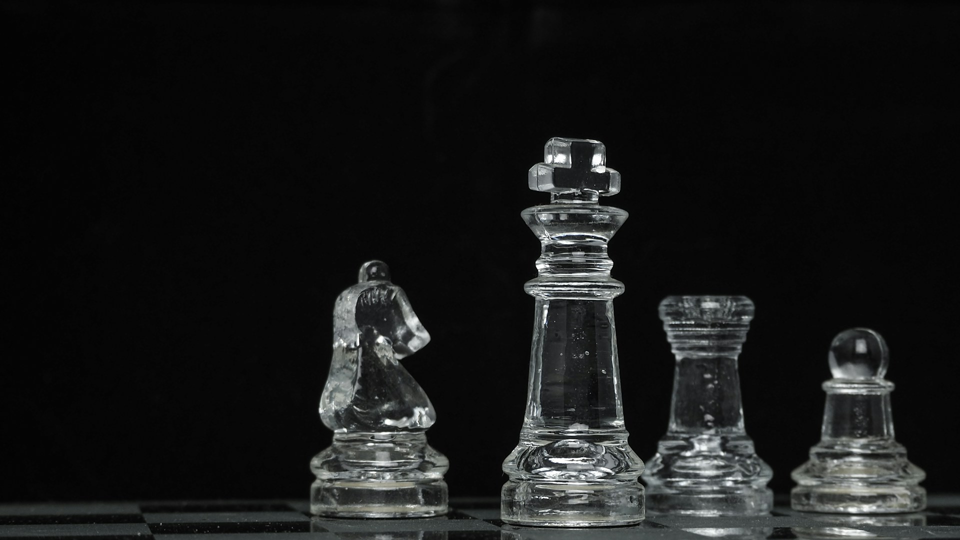 clear glass chess piece on black surface