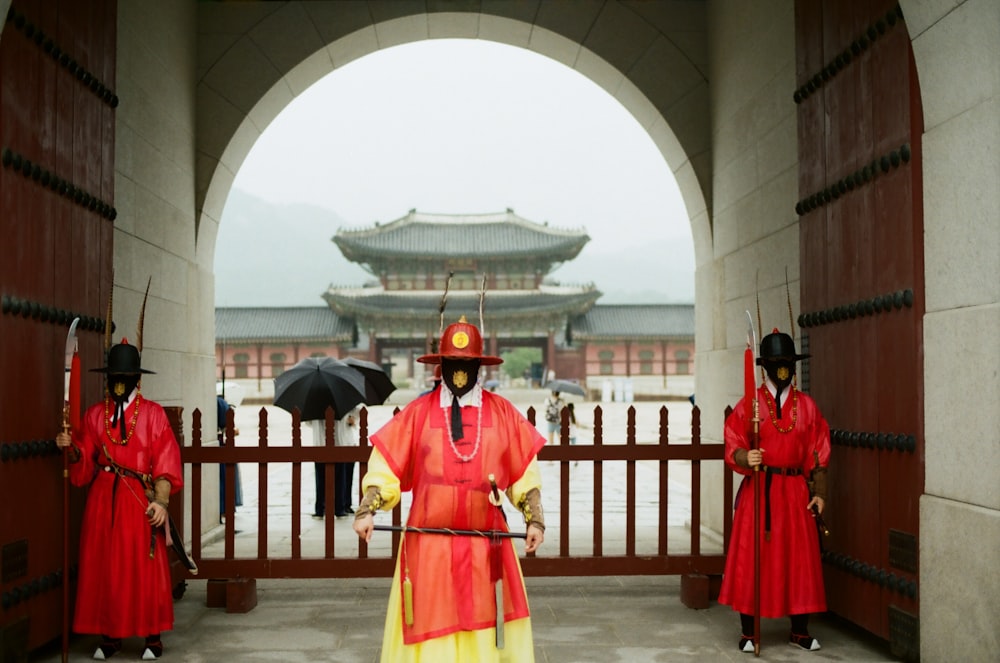 people in red and yellow traditional dress standing on gray concrete floor during daytime