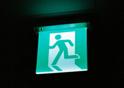 Bright industrial safety signs clearly marking emergency exits in a factory setting.