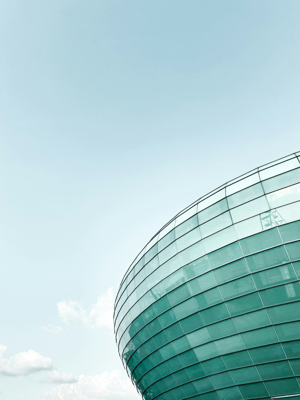 glass walled high rise building under white clouds during daytime