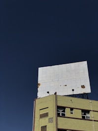 Workers restoring an old, weathered billboard with fresh paint and new lighting.