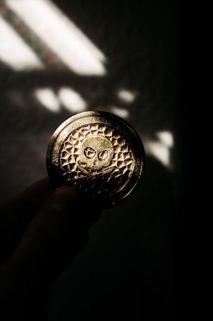 A hand holding a small silver round, emphasizing its compact size and craftsmanship.