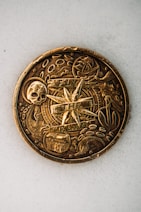 gold round coin on white textile