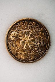 gold round coin on white textile