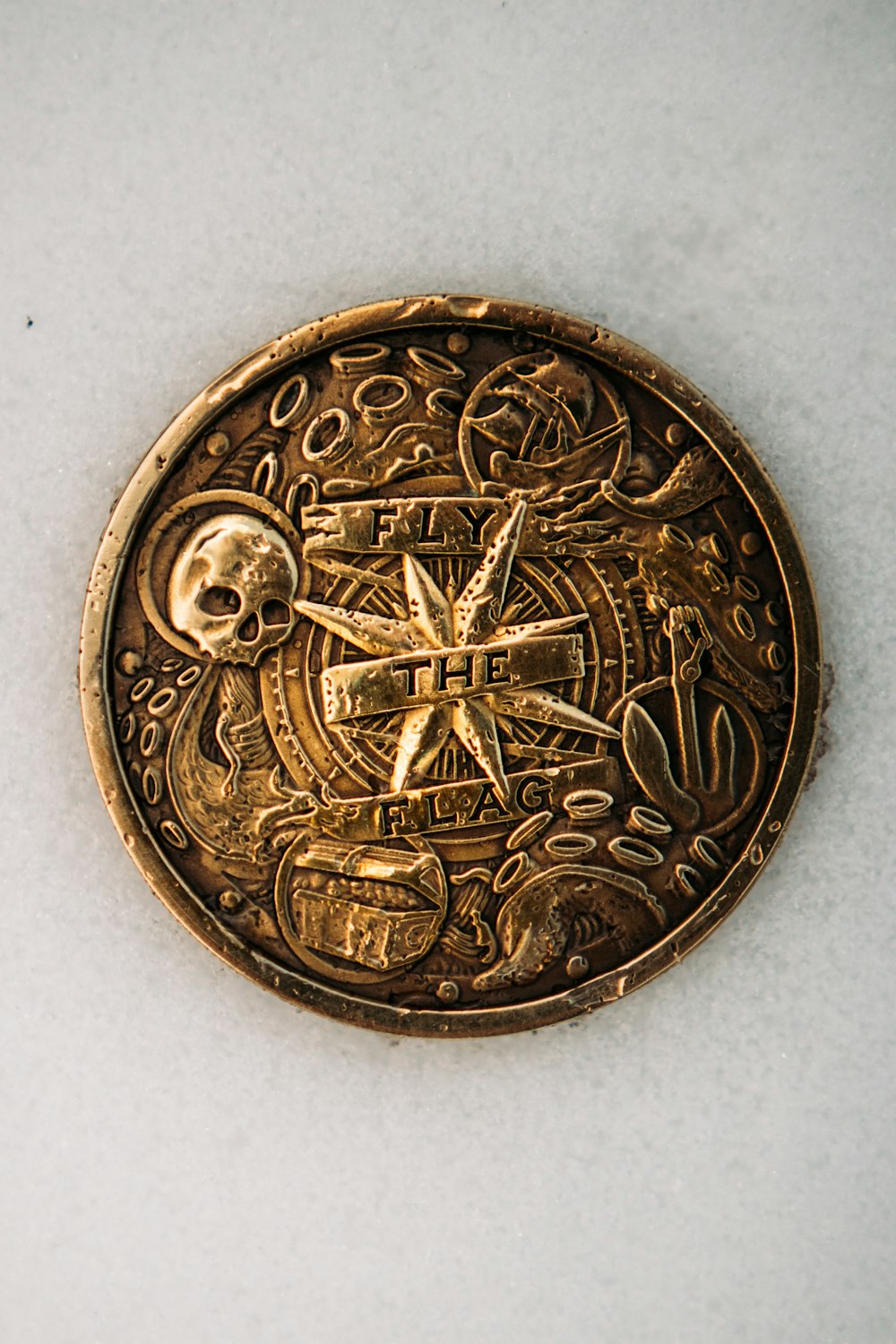 gold round coin on white textile