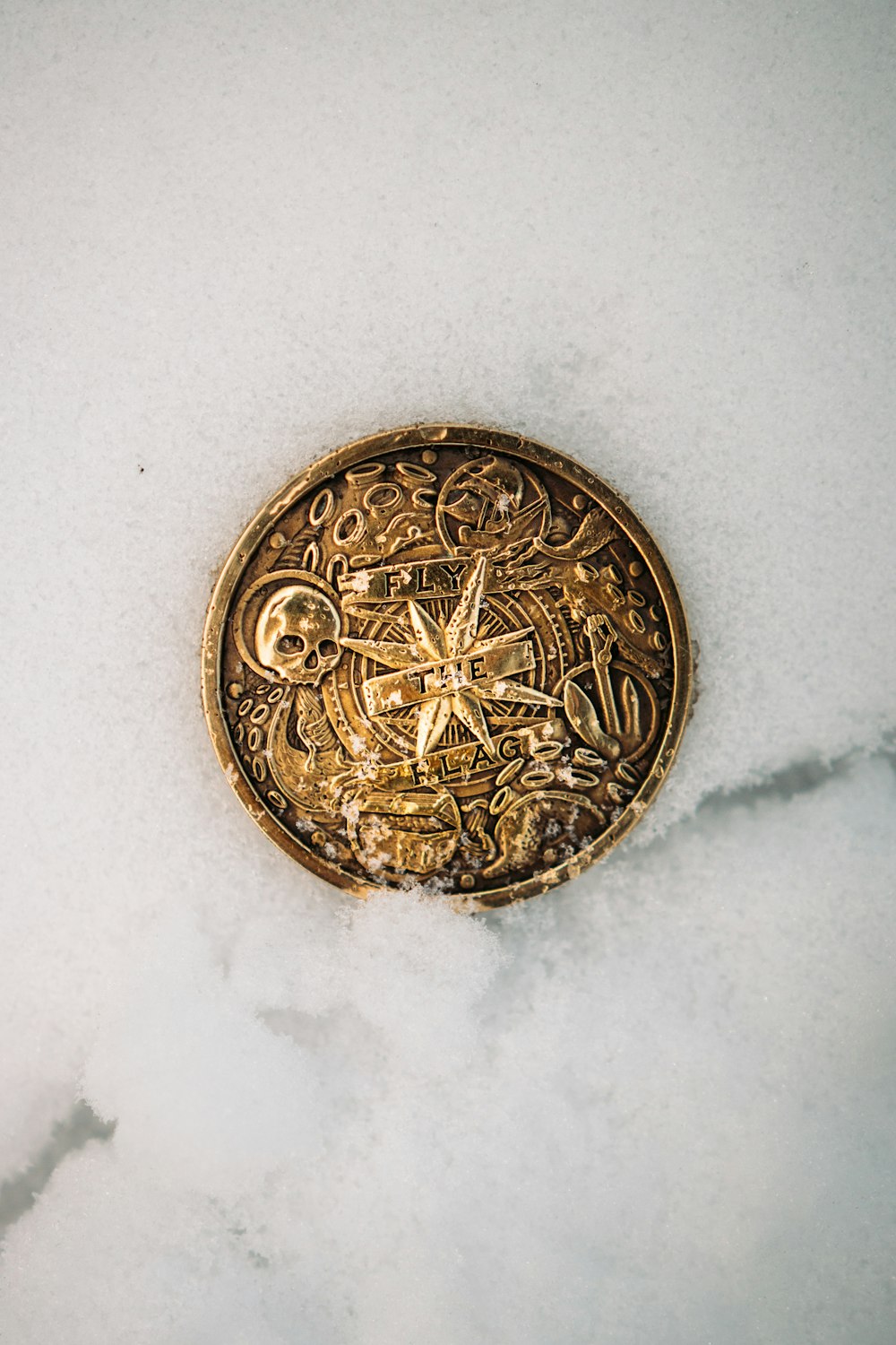 gold round coin on white textile