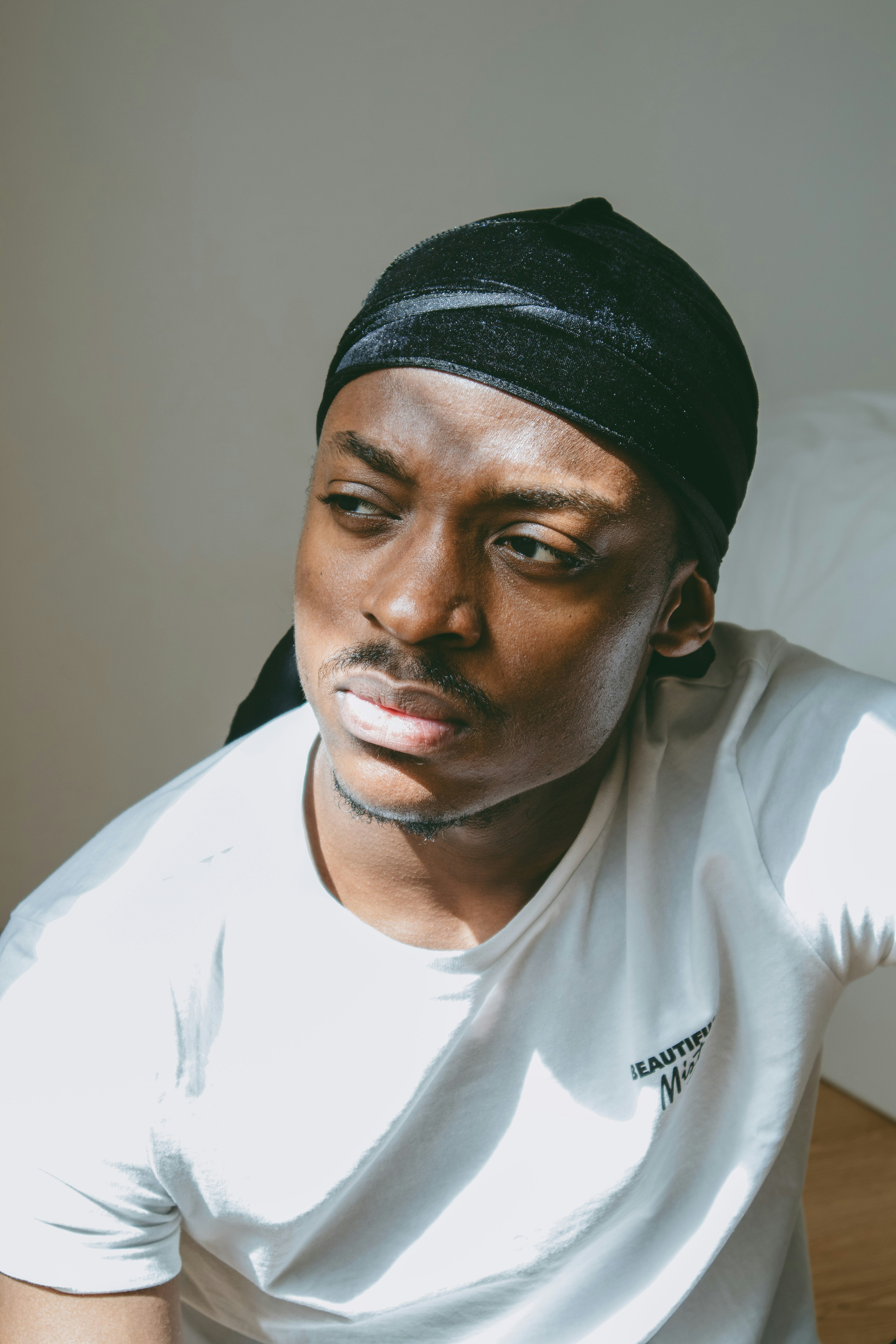 黒いニット帽をかぶった白いクルーネックのtシャツを着た男性の写真 Unsplashの無料写真