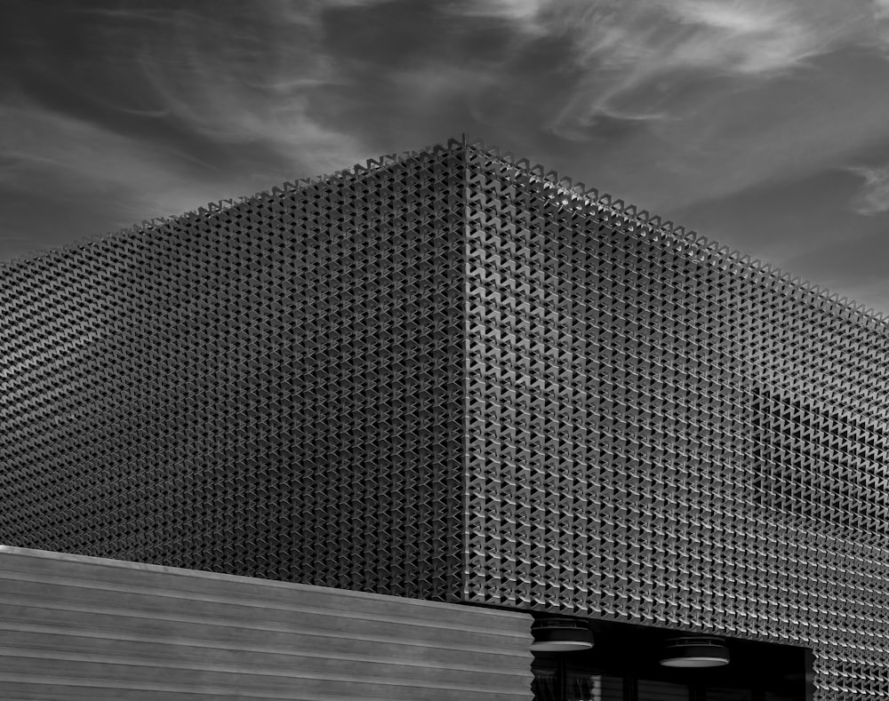 grayscale photo of building under cloudy sky