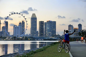 Group of happy bike riders celebrating successful job placements in front of Dubai skyline.