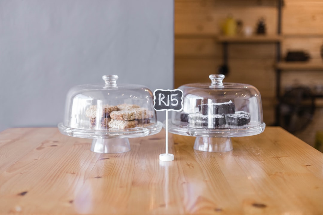 clear glass cake dome on brown wooden table