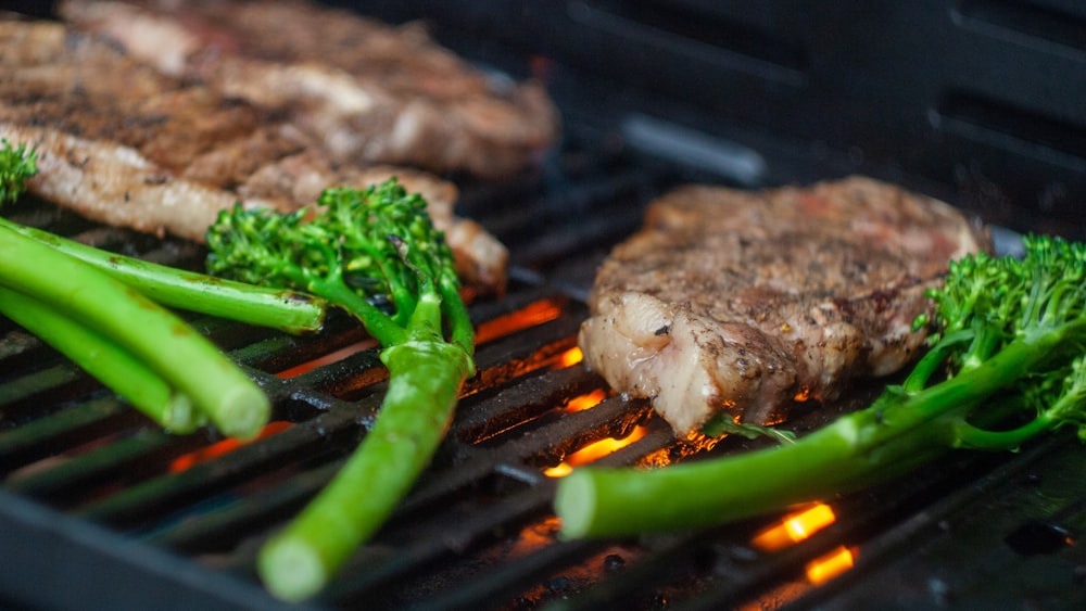 grilled meat with green vegetable on black grill