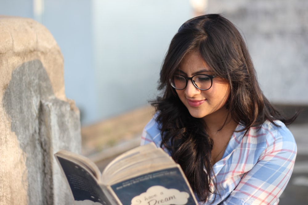 woman in red and white plaid shirt wearing black framed eyeglasses