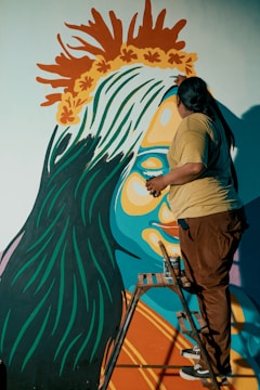 A skilled painter at work on a vibrant mural.