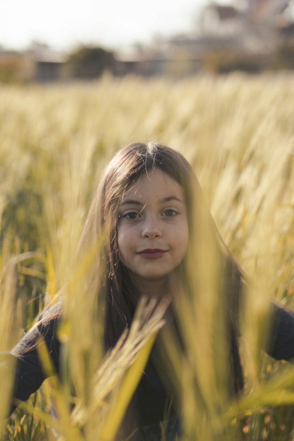 Muchacha con camisa negra de pie en el campo de trigo durante el día