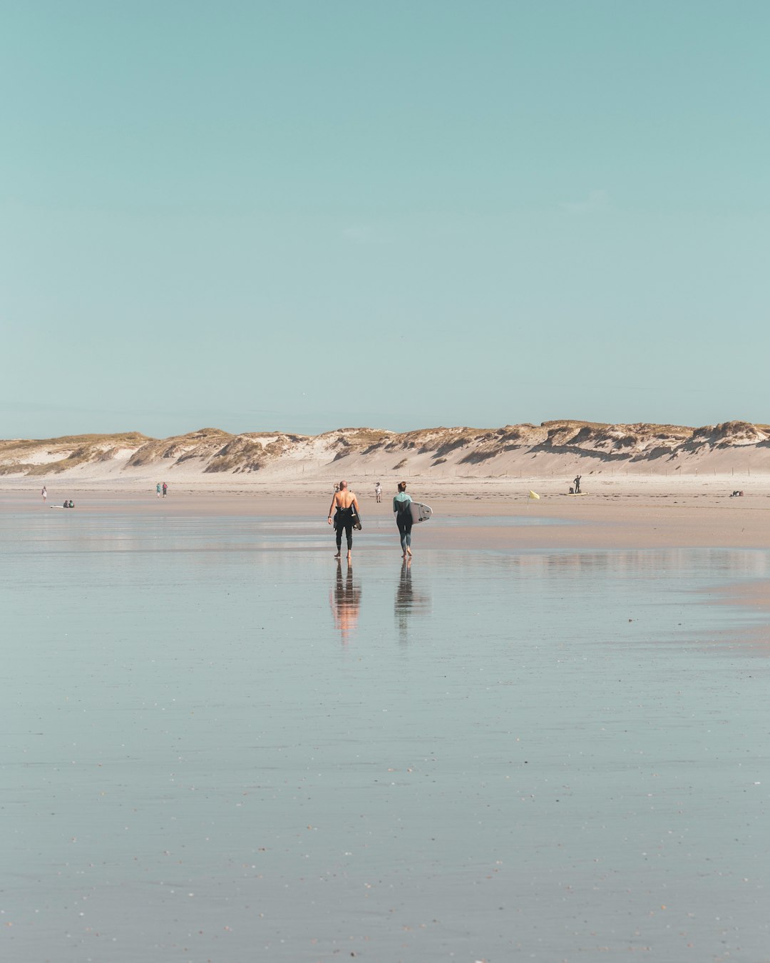2 person walking on beach during daytime