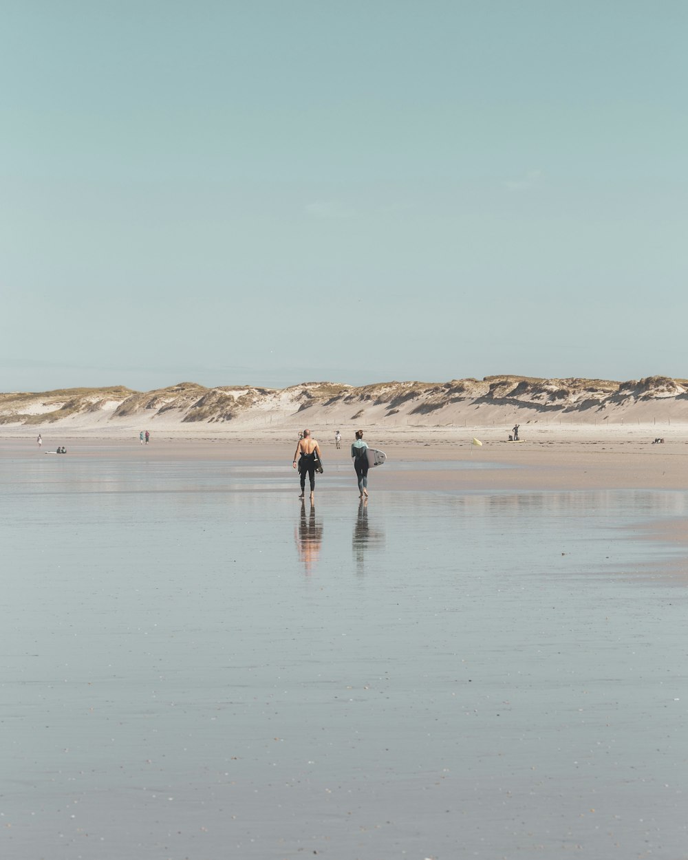 2 person walking on beach during daytime