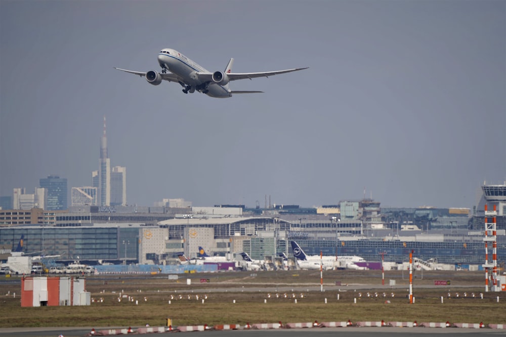 avion blanc survolant la ville pendant la journée