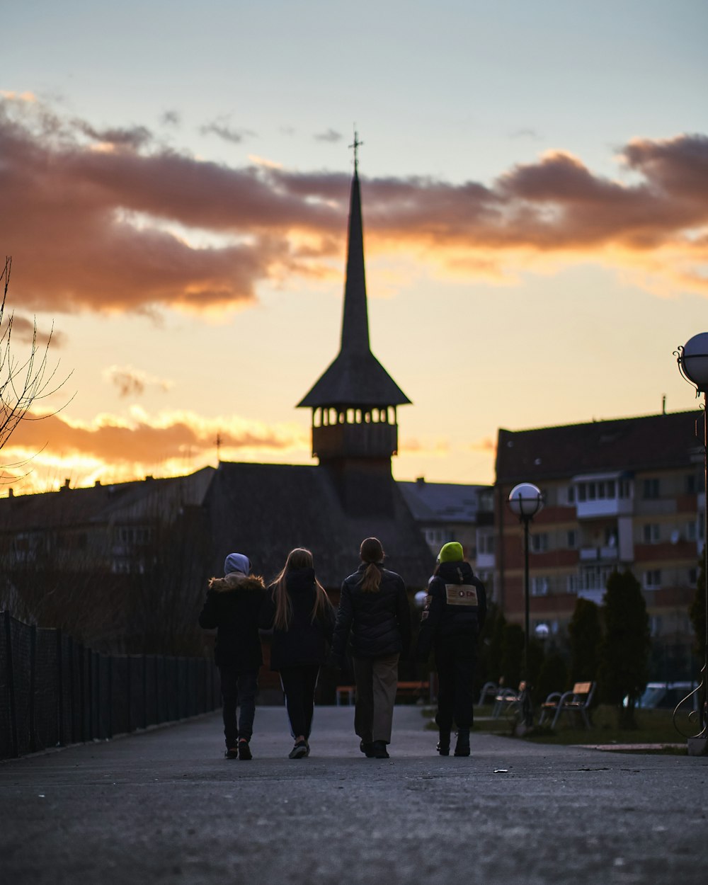 people walking on sidewalk near building during sunset