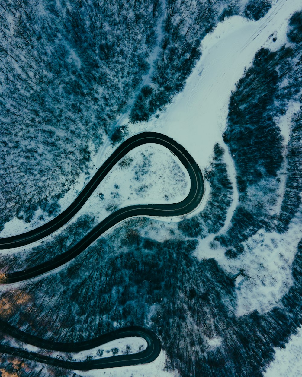 aerial view of road in the middle of snow covered ground