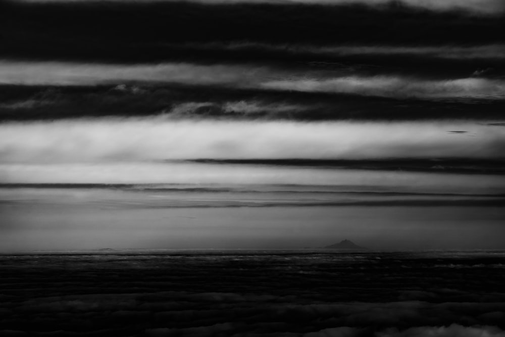 grayscale photo of clouds over the sea