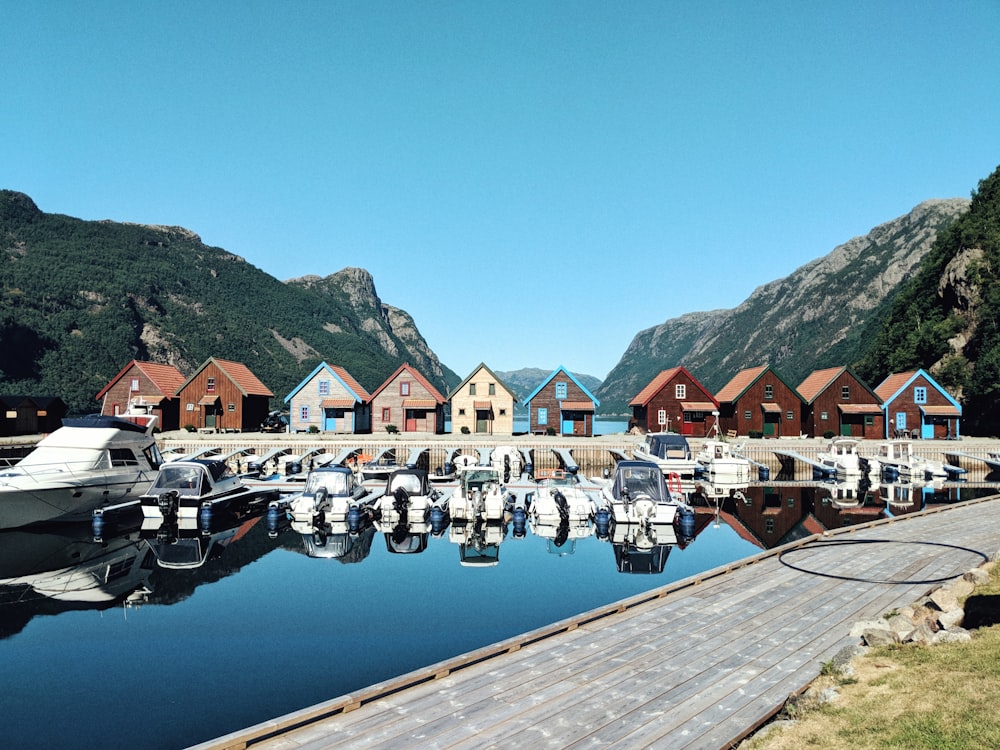 houses near lake and mountain during daytime