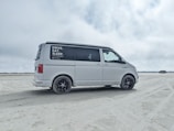 A sleek white van parked by a sunny Florida beach.