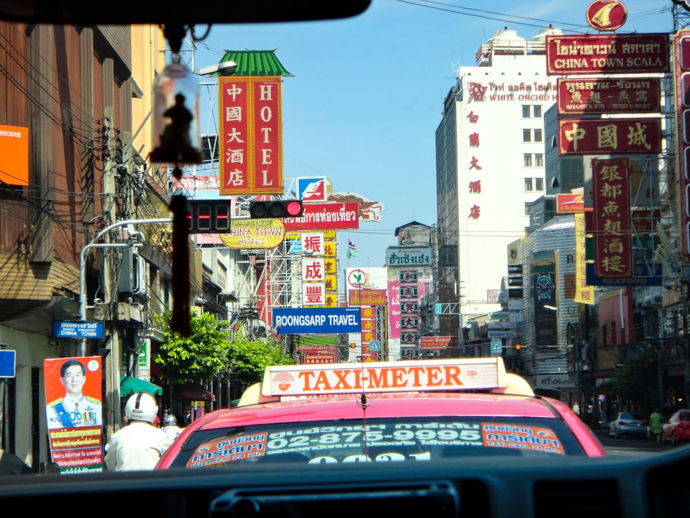 red car on road near buildings during daytime