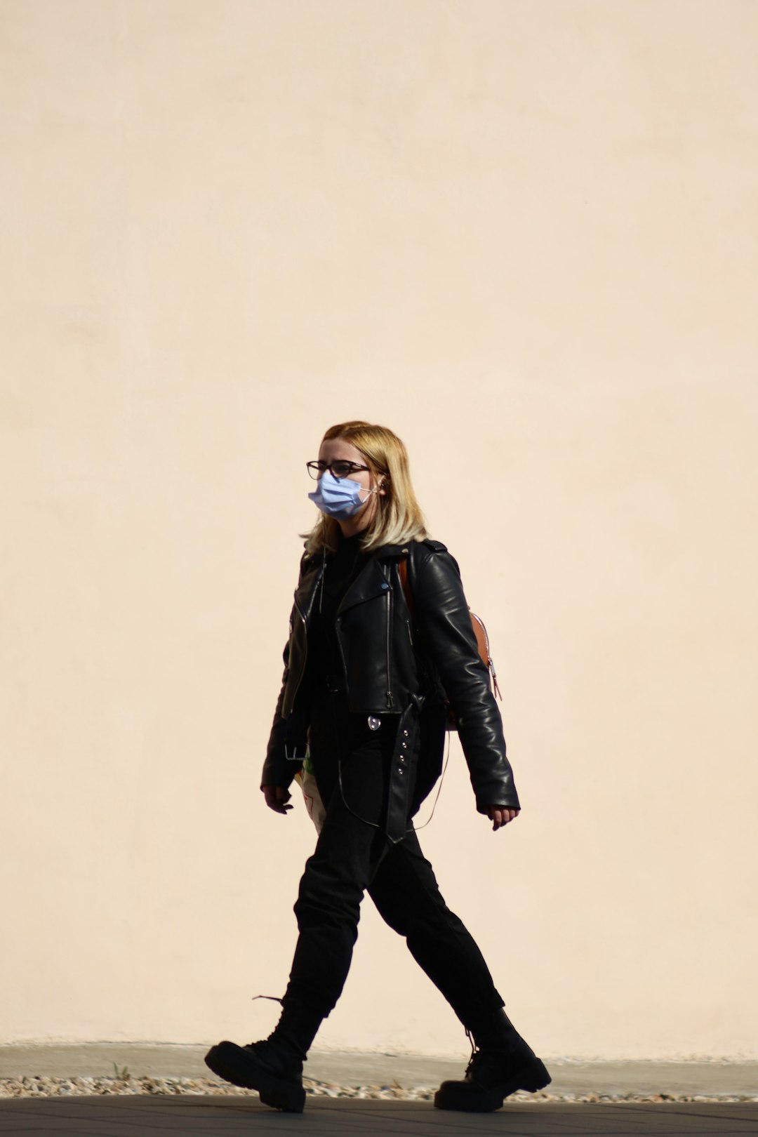 woman in black leather jacket and black pants standing and smiling