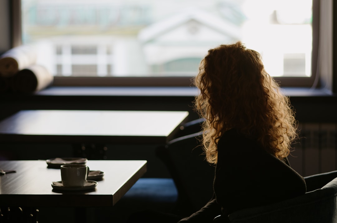 woman in black long sleeve shirt sitting by the table