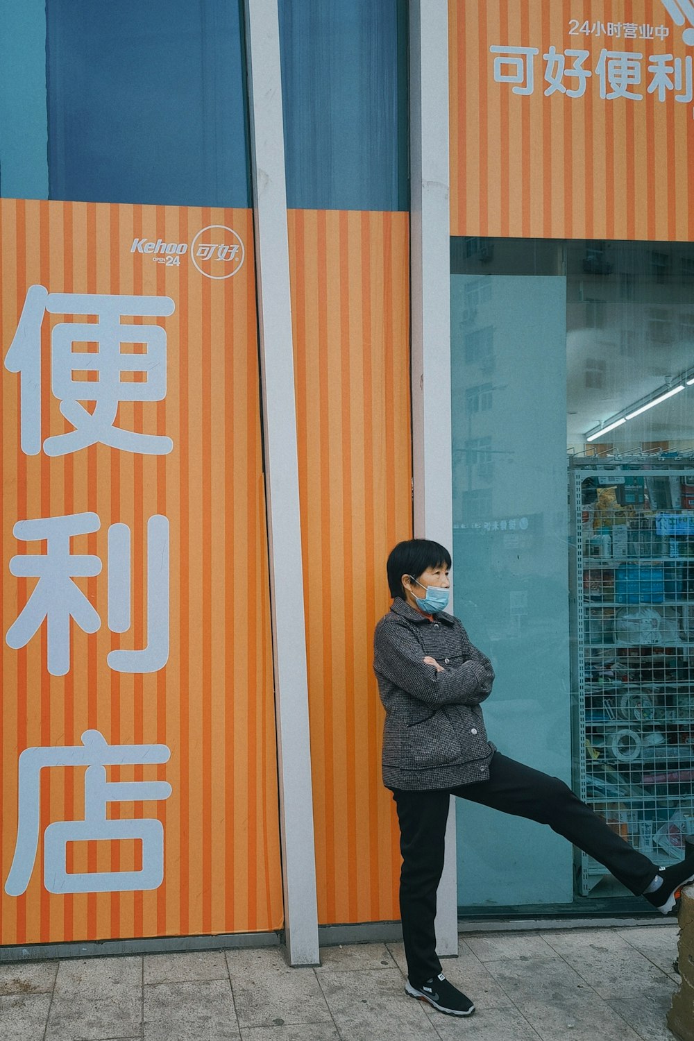 woman in black coat standing beside glass wall