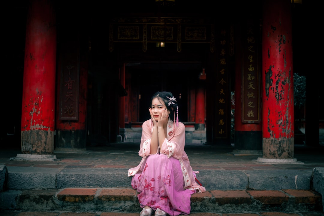 woman in pink dress sitting on concrete floor