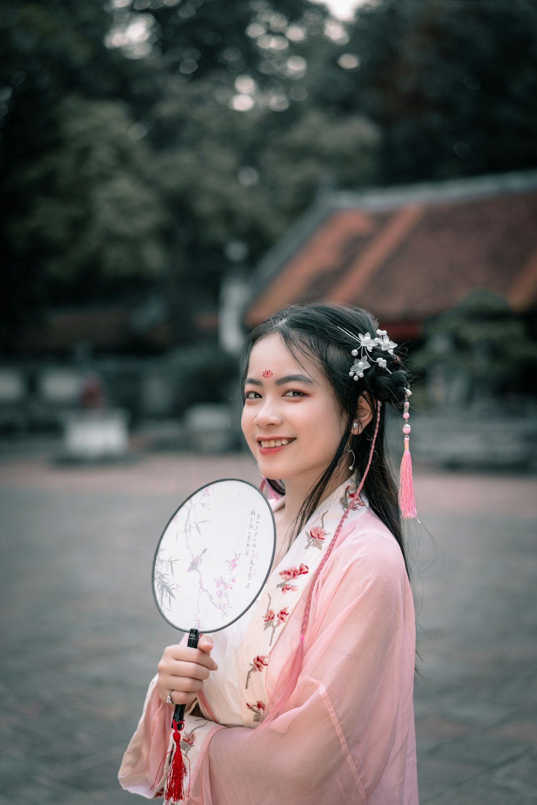 woman in pink shirt holding white hand fan