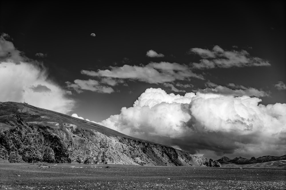 grayscale photo of mountain under cloudy sky