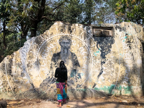 Still frame showing a vibrant mural on a weathered border wall illuminated by early morning light.