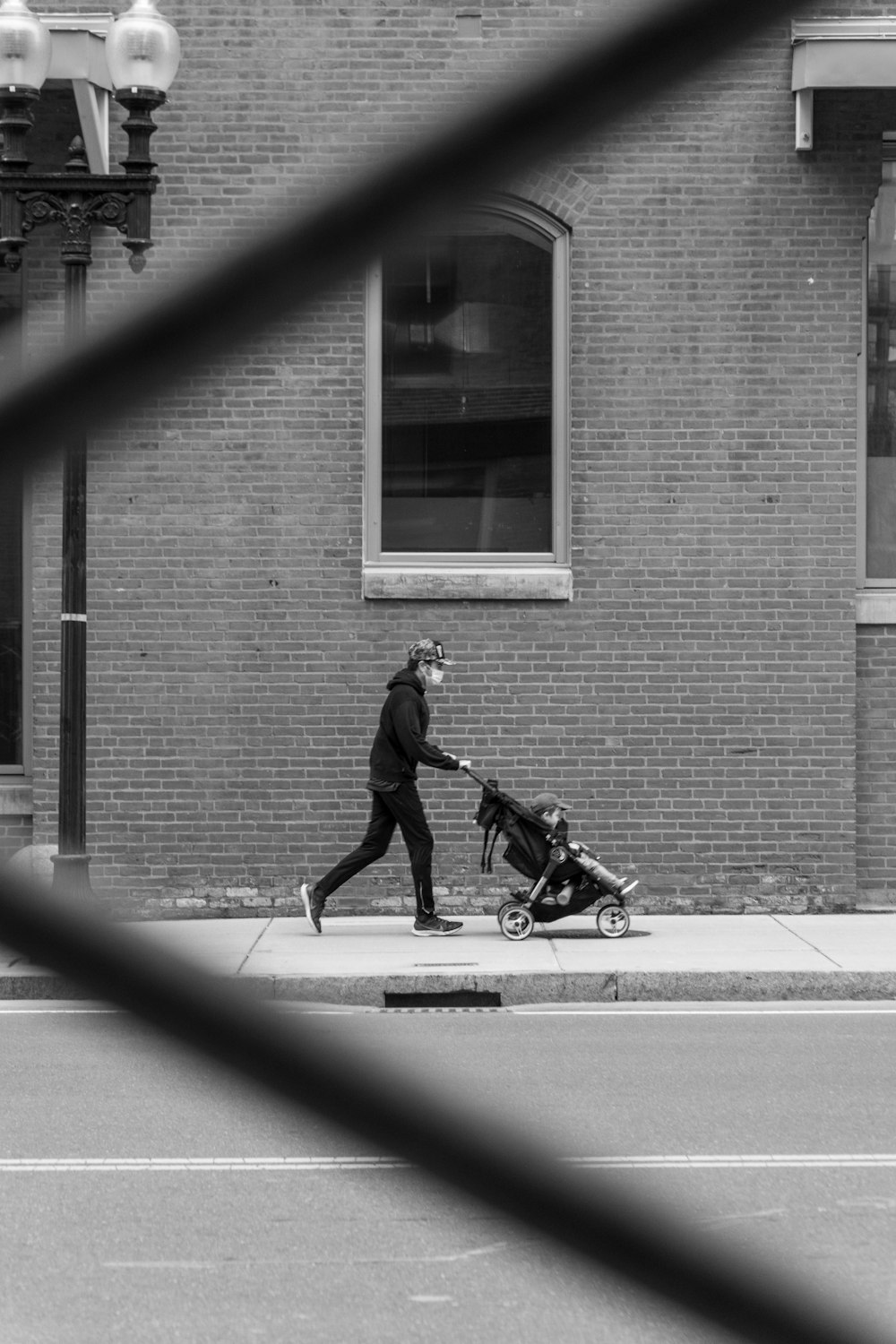 man in black jacket and pants riding bicycle in grayscale photography
