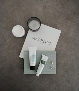 Minimal flat lay of natural beauty products and a warm taupe journal beside a pilates ring.