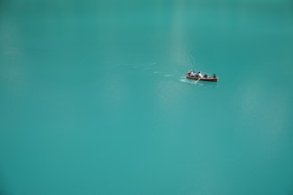 2 people riding on boat on body of water during daytime