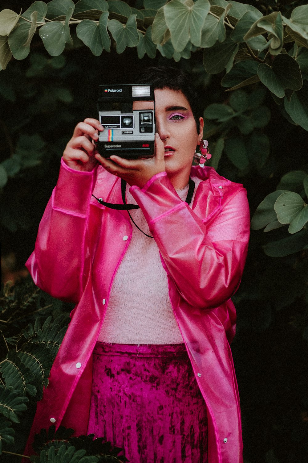 woman in pink jacket holding black and gray camera