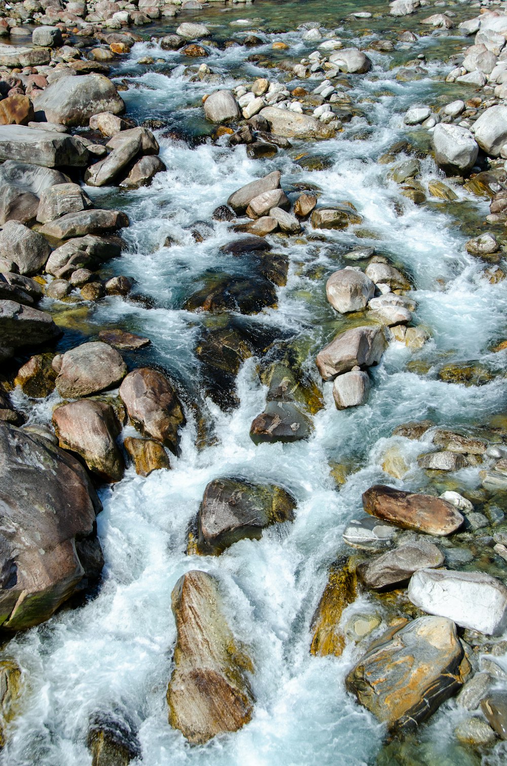 rochas cinzentas e castanhas no rio