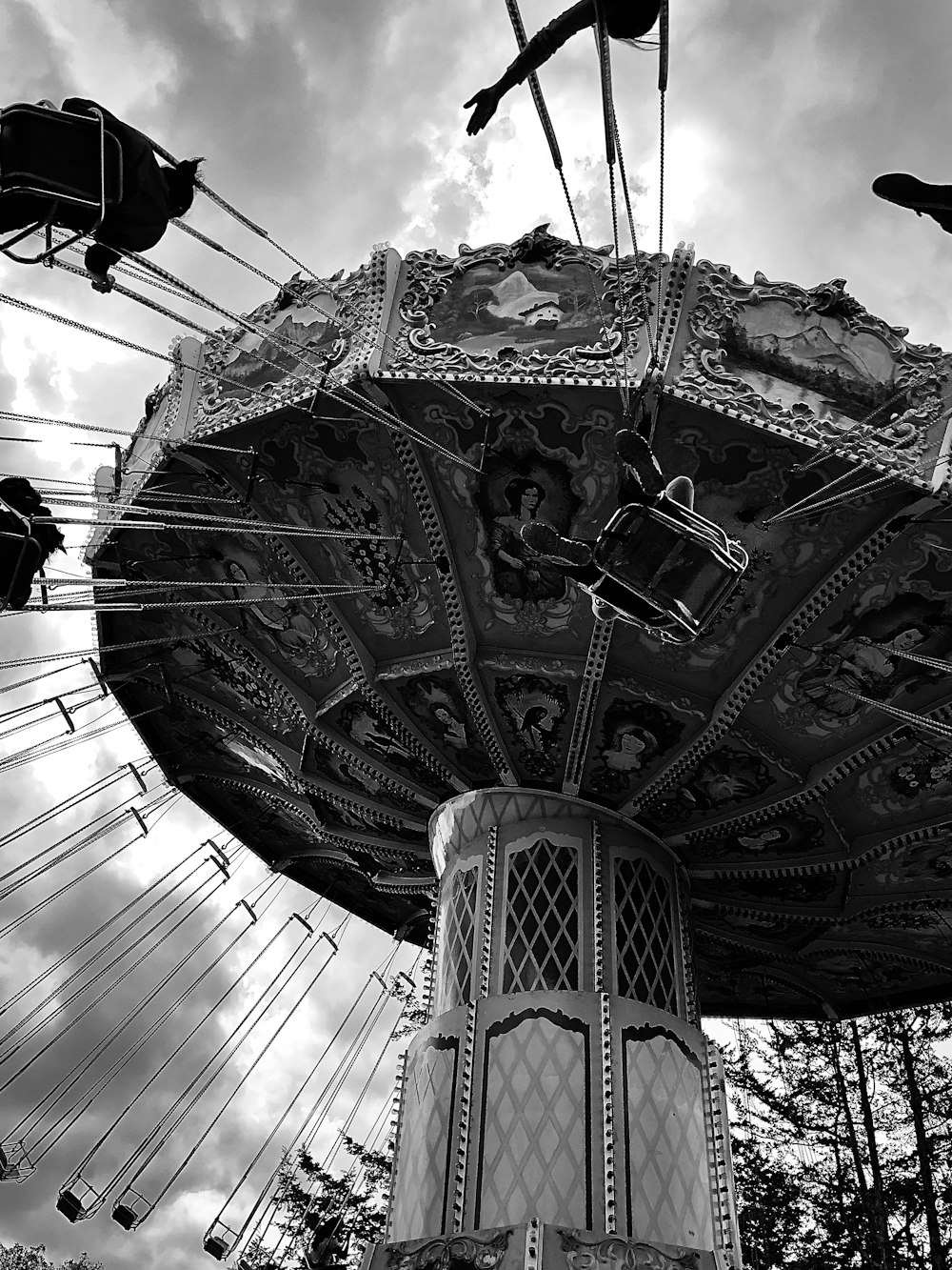 grayscale photo of people riding on swing carousel