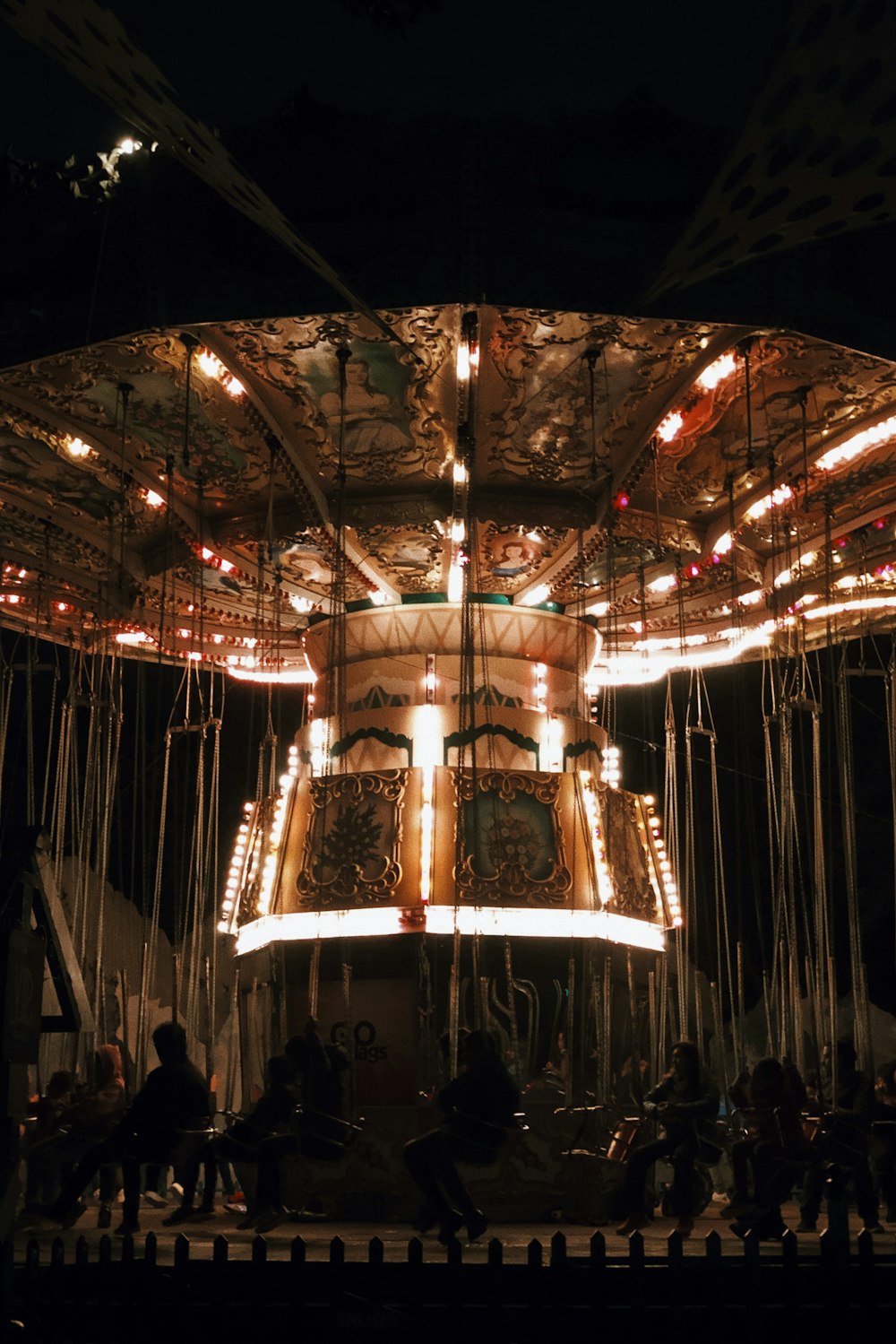 people standing near lighted carousel during night time