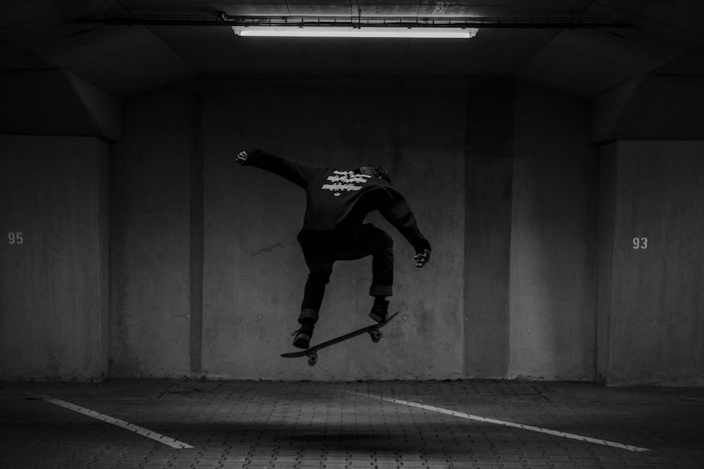 man in black and white long sleeve shirt and black pants jumping on gray concrete floor