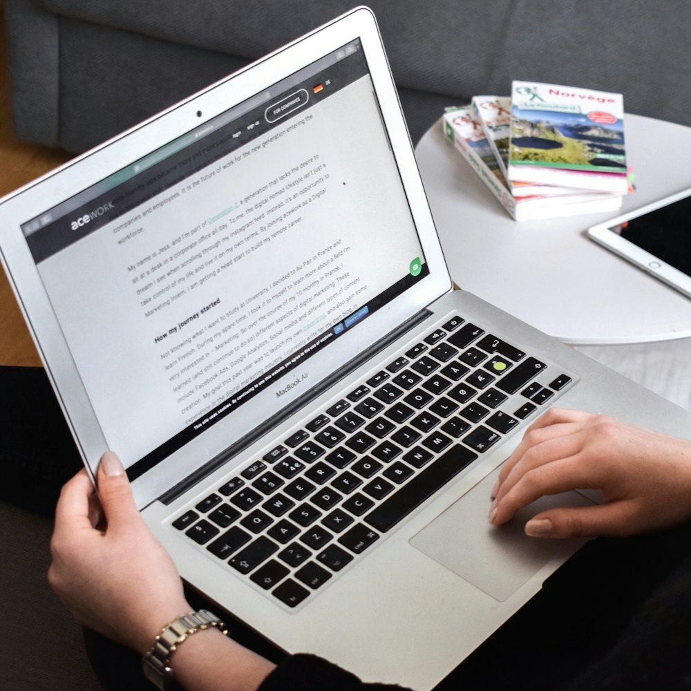 person using macbook air on lap