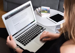 person using macbook air on lap