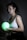 Photo of a woman in her 30s holding a bioenergy pod with a glowing teal background.