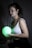 Photo of a woman in her 30s holding a bioenergy pod with a glowing teal background.