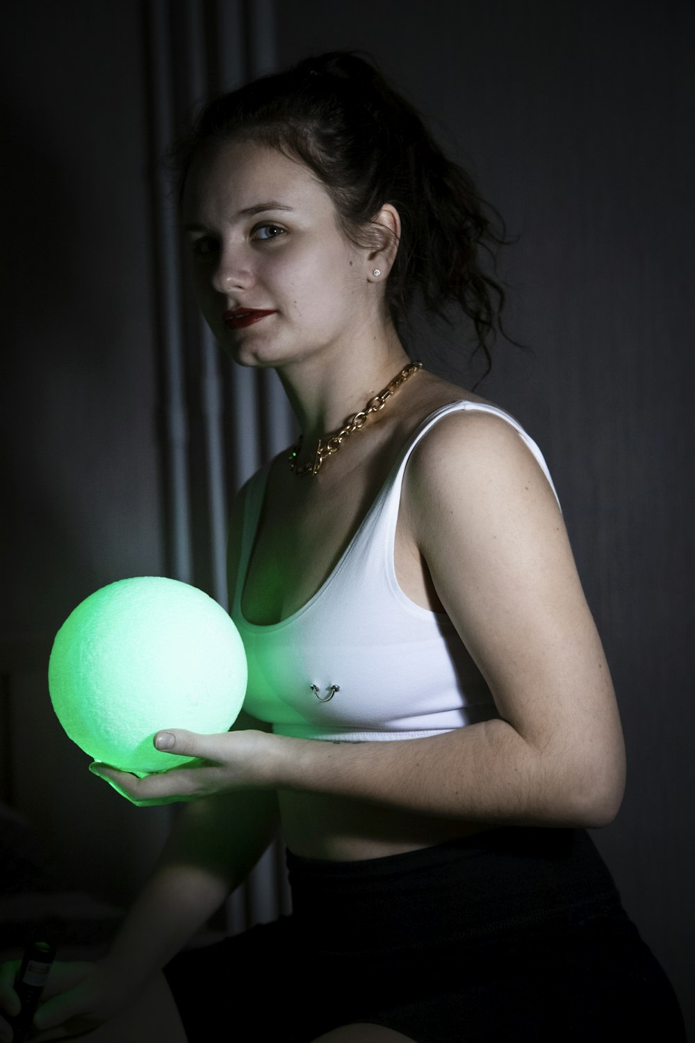 woman in white tank top holding pink balloon