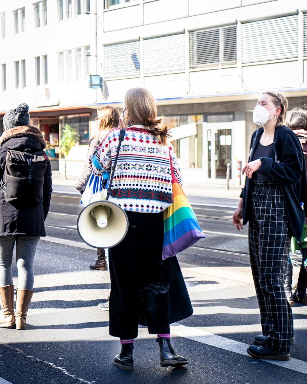 woman in blue and white long sleeve shirt and blue pants walking on sidewalk during daytime