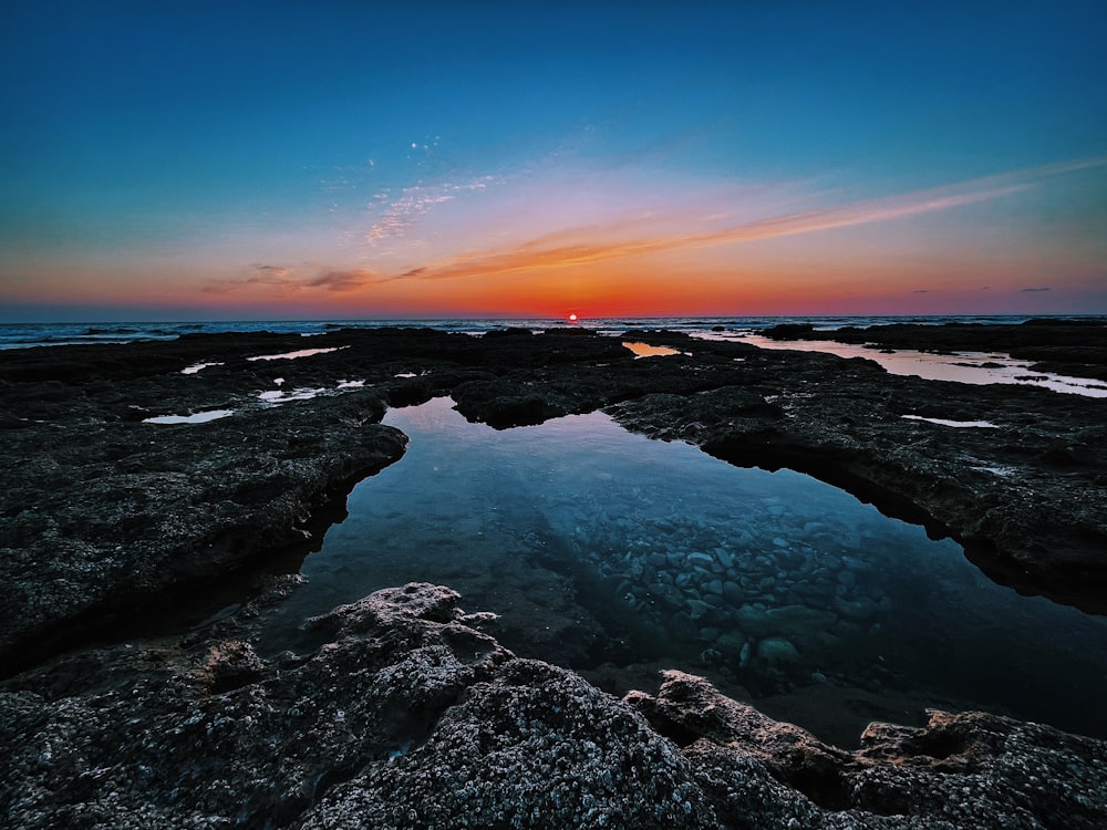 rocky shore under blue sky during daytime