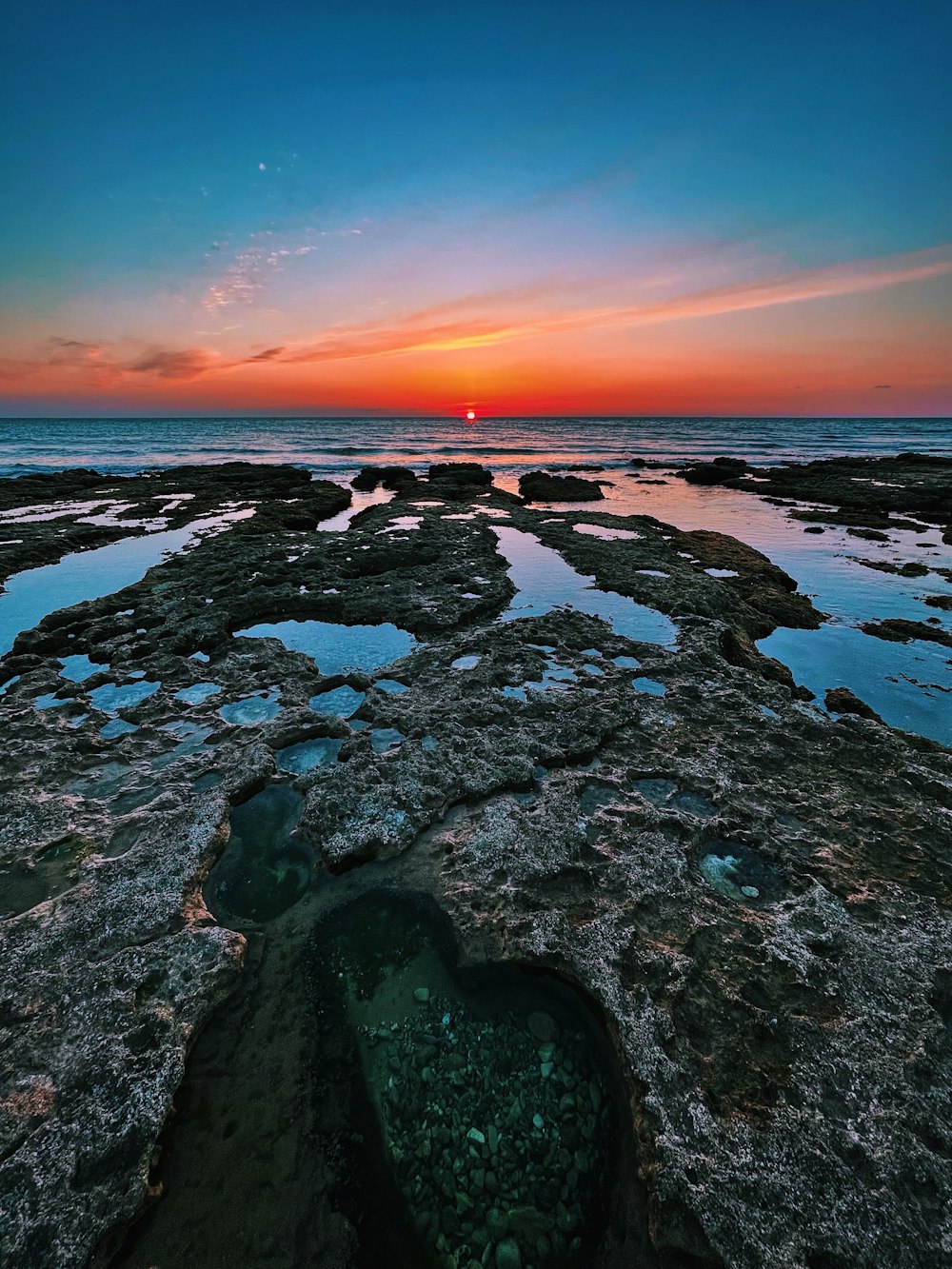 rocky shore during sunset under blue sky